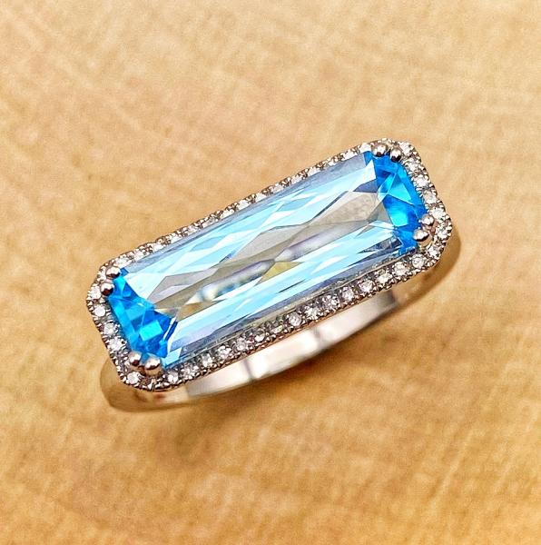 14 karat white gold ring with a custom faceted baguette cut Swiss blue topaz and diamonds. $1155.00