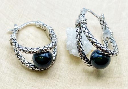Sterling silver earrings with an 8mm black onyx bead and diamond accents. $300.00