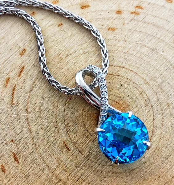 14 karat white gold pendant fashioned with a 6.88ct checkerboard faceted Swiss blue topaz and 10 brilliant cut diamonds. *sold*