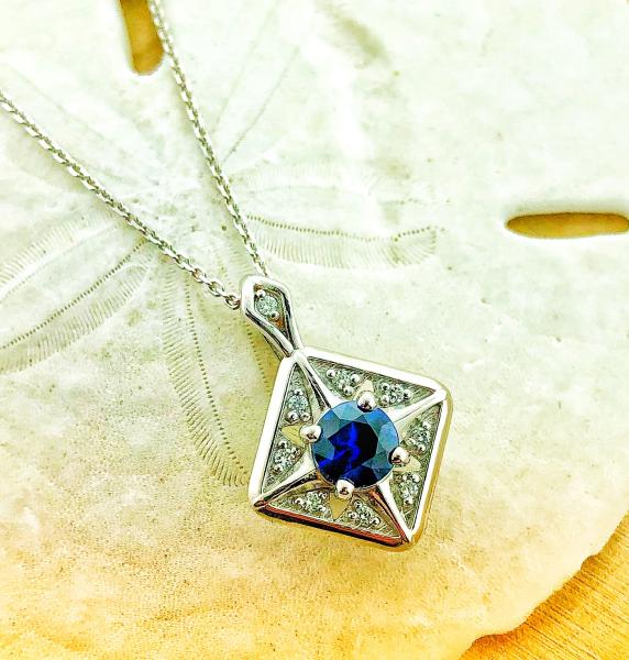 14 karat white gold necklace with a 0.64 carat bright blue sapphire and brilliant cut accent diamonds. Designed by Kurt Rose. $2430.00