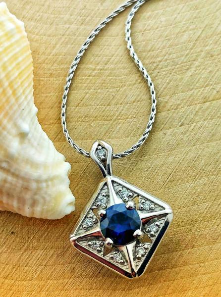 14 karat white gold necklace with a 0.64 carat bright blue sapphire and brilliant cut accent diamonds. $2430.00
