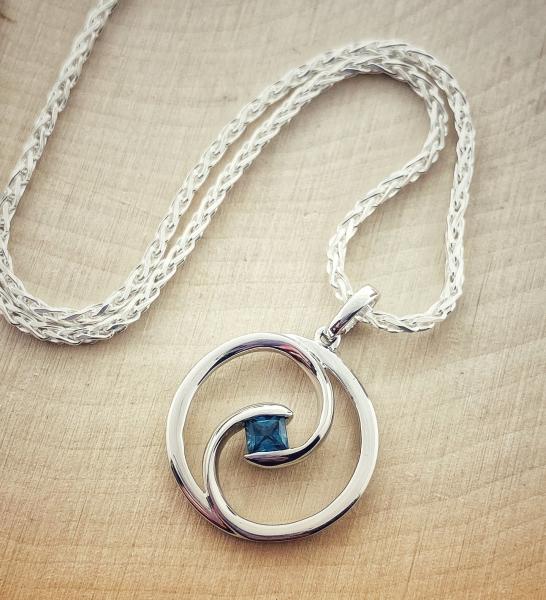 Sterling Silver princes cut blue sapphire swirl pendant on 16" chain. 
*sold*