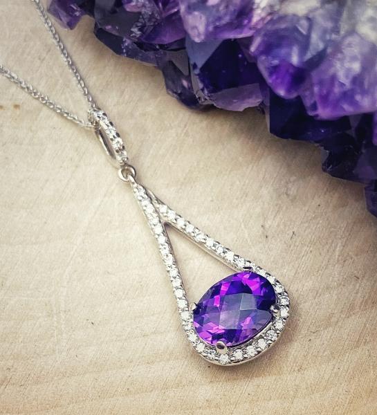 14 karat white gold necklace with an oval checkerboard cut amethyst and brilliant cut diamonds. $1536.00