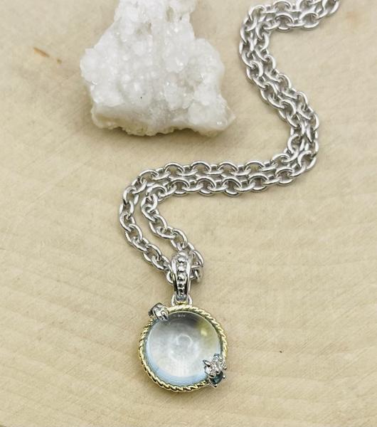 Sterling silver/18K yellow gold cab blue topaz, diamond and sapphire pendant on chain.