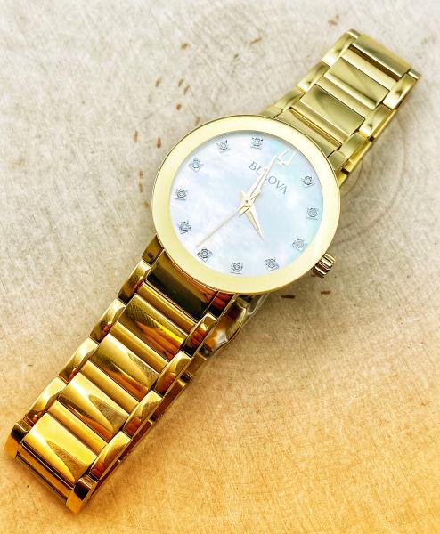 Ladies Bulova stainless steel yellow gold tone watch, mother of pearl face, diamond markers. $450.00 