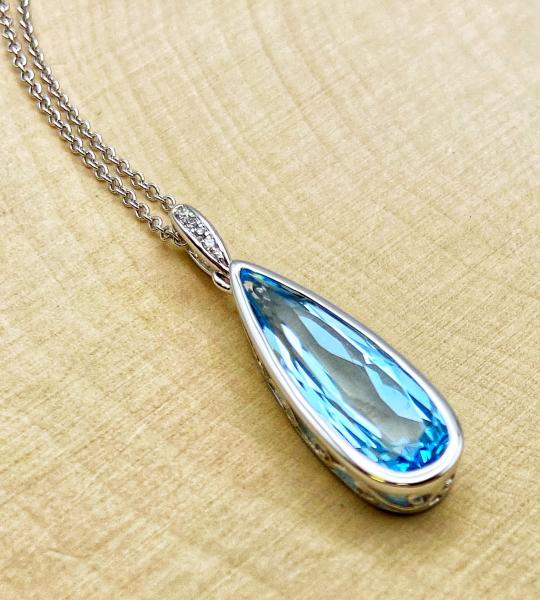Tear drop 14 karat white gold blue topaz and diamond necklace. $1015.00