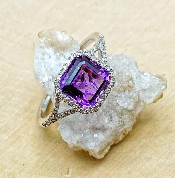 14 karat white gold ring with a square step cut amethyst and diamond ring. $1035.00