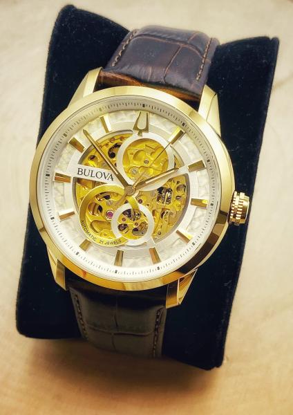 Yellow gold electroplate Bulova skeleton watch with a lizard grain strap. $595.00