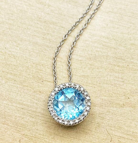 14 karat white gold sky blue topaz and diamond halo necklace. $690.00