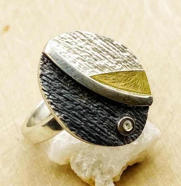 Sterling silver and 18 karat gold oval ring with diamond accent. $250.00