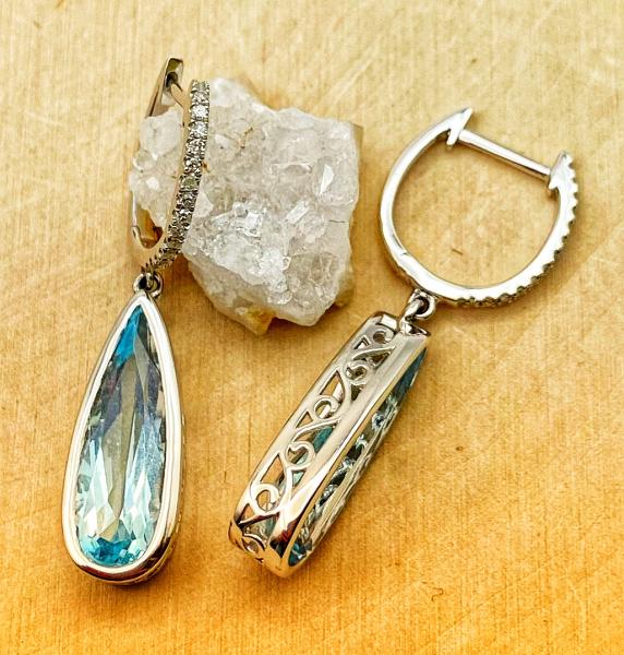 14 karat white gold tear drop blue topaz and diamond dangle earrings. $1300.00