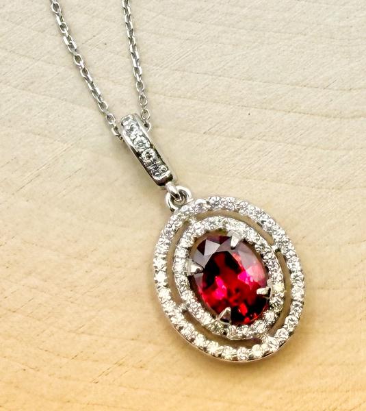14 karat white gold vivid 0.99 carat oval ruby and diamond double halo necklace. $5,250.00