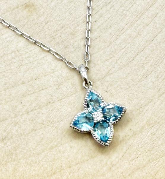 14 karat white gold blue topaz and diamond flower necklace. $935.00