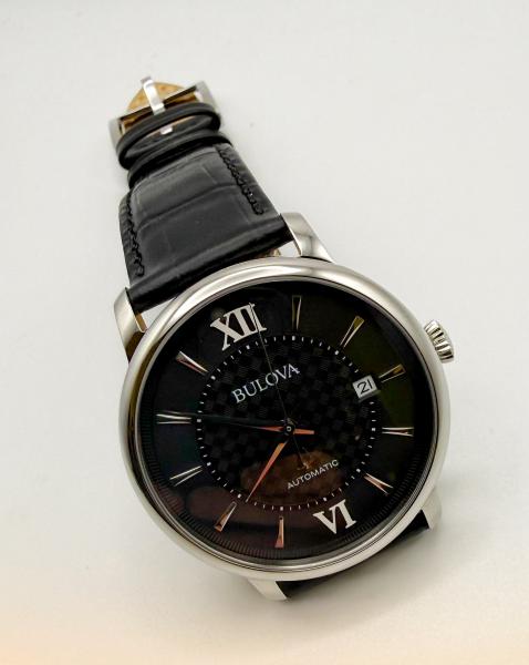 Gentlemen's Bulova automatic with a black pleated dial and stainless steel case. $625.00