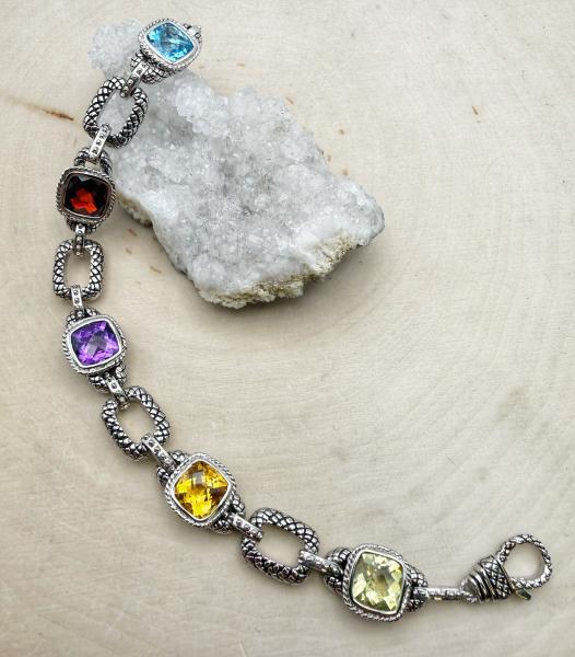 Sterling silver bracelet with checkerboard cushion cut lemon quartz, citrine, amethyst , garnet and Swiss blue topaz. $875.00