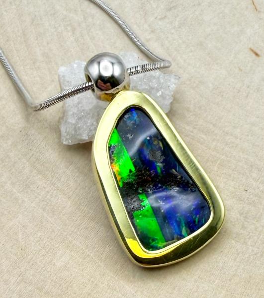 6.48 carat boulder opal set in 18 karat green gold. 18 karat white gold bail and chain. $4700.00