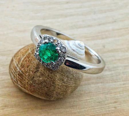 14 karat white gold ring with a 0.36 carat round emerald and a cushion diamond halo. $1100.00