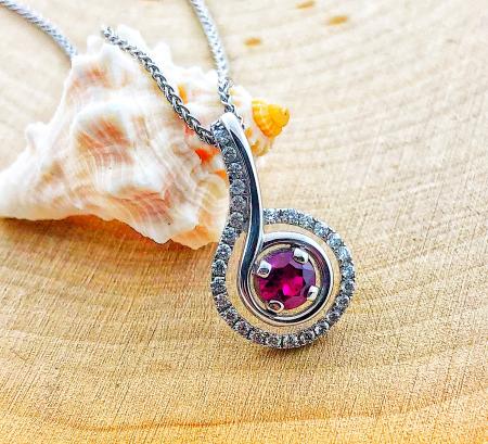 14 karat white gold ruby and diamond necklace. The round Madagascar ruby weighs  0.40 carat and the brilliant cut diamonds total 0.22 carat. $2425.00