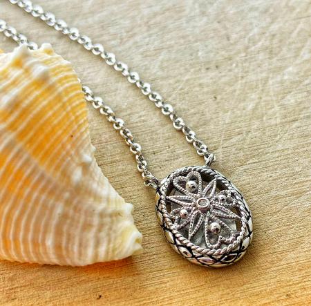 Sterling silver diamond filigree oval pendant stationed on chain. $150.00