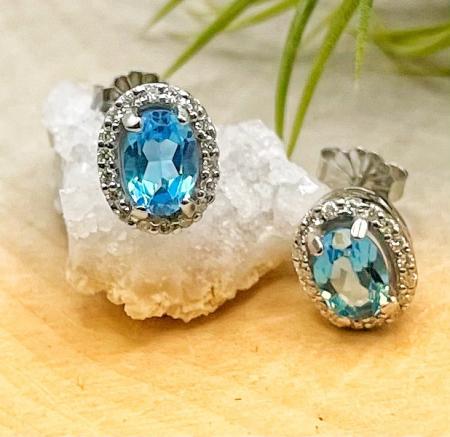 14 karat white gold, oval 5x7mm blue topaz with .24ctw lab diamond halo stud earrings. $1090.00
