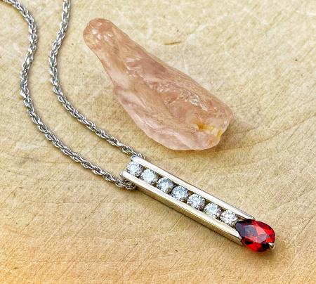 18 karat white gold garnet and diamond bar pendant. $1153.00 **Sold, may be special ordered**