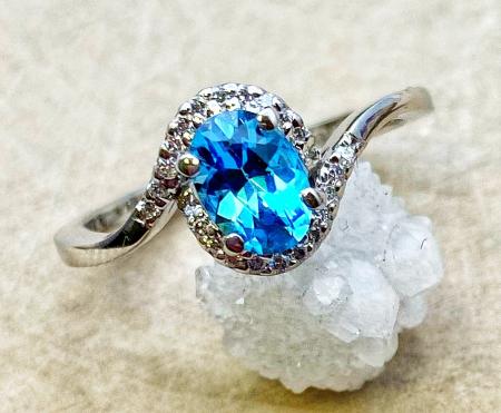 14 karat white gold oval blue topaz and .10ctw lab diamond accented ring. $850.00
