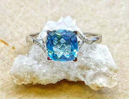 14 karat white gold 1.71ct cushion blue topaz and .08ctw lab diamond accented ring. $780.00