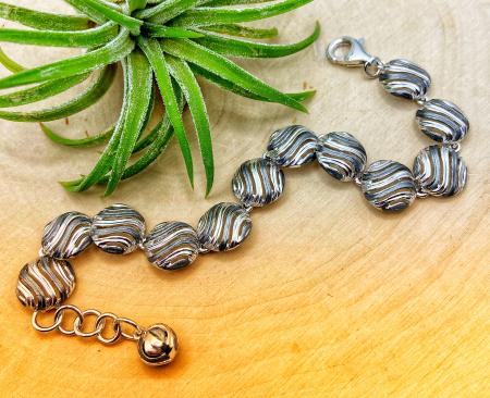 Sterling silver and black ruthenium swirl disc bracelet. $660.00