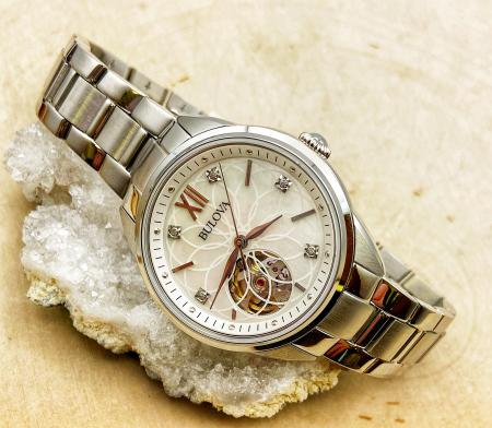 Ladies Bulova stainless steel, mother of pearl face, diamond bezel, automatic watch. $550.00