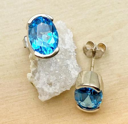 14 karat white gold half bezel Swiss blue topaz earrings. $575.00