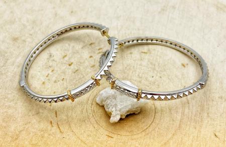 Sterling silver diamond hoops with 18 karat gold accents. $575.00