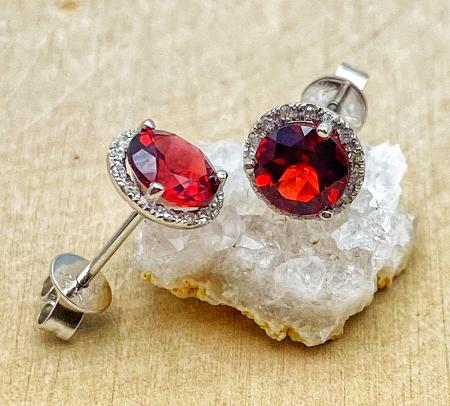 14 karat white gold garnet and diamond halo stud earrings. $590.00