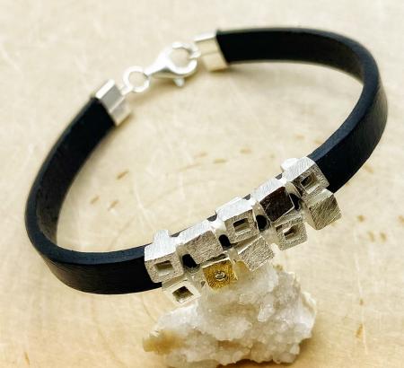 Sterling silver and 18 karat gold squares on a leather bracelet. $300.00