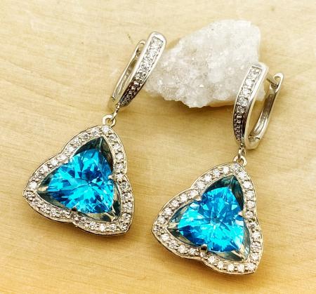 6.80 carat total weight trillion cut Swiss blue topaz earrings with 0.47 carat total in diamonds. Fashioned in Continuum Sterling Silver.