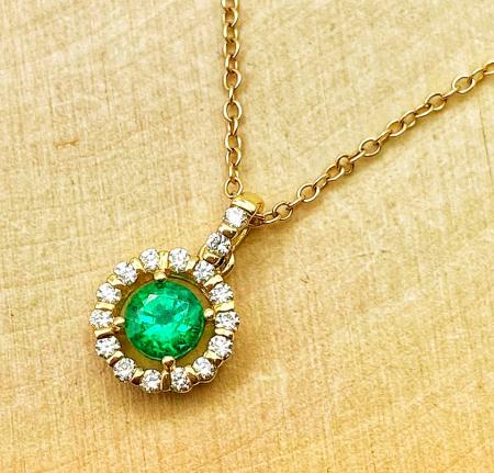 14 karat yellow gold emerald and diamond halo necklace. $3050.00