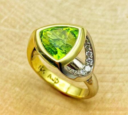 18 karat green and white gold ring with a custom faceted 4.59 carat trillion peridot and brilliant cut diamonds. 140-13636
