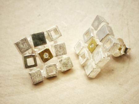 Sterling silver and 18 karat gold squares earrings with a diamond accent. $385.00