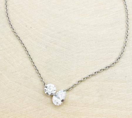 14 karat white "floating" diamond necklace with one round and one pear shape lab grown diamond totaling 0.65 carat. $1650.00