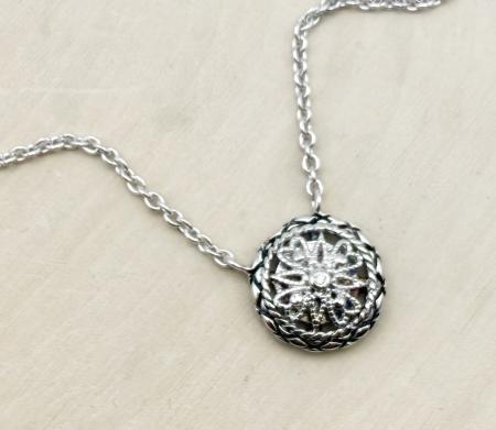 Sterling silver round filigree necklace with diamond accent.  $150.00