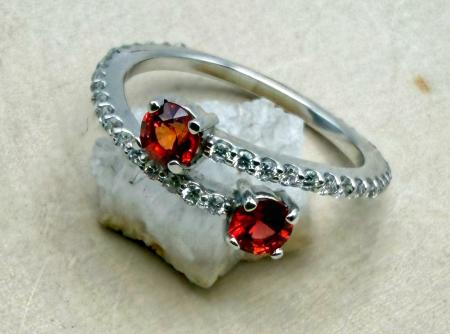 14 karat white gold red-orange  sapphire and diamond bypass ring. $1750.00